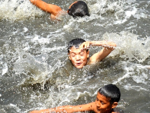 Pakistani youths cool off near floating trash in a polluted canal during a hot day in Rawalpindi May 11, 2012. Heat-wave conditions in Pakistan brought a high of 41 degrees celsius in some parts of the country. PHOTO: AFP 