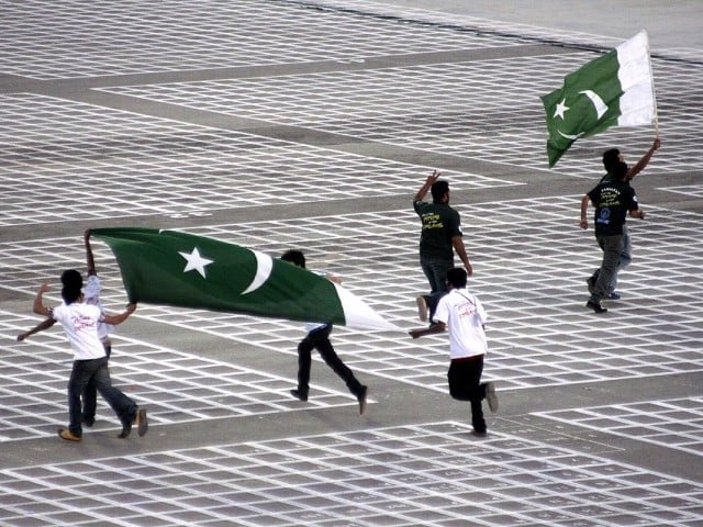 Some kids run with the Pakistani flag prior to the record attempt in Lahore. PHOTO: SHAFIQ MALIK